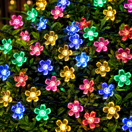 Farbenfrohe LED Blumenlichterkette für eine romantische und dekorative Gartenbeleuchtung am Abend.
