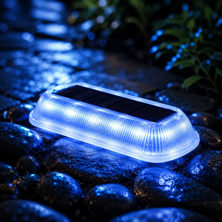 Kaltweiße Solar Bodenleuchte mit Solarpanel auf nassem Kies, IP65 LED-Gartenleuchte für Wege, Einfahrt und Außenbereich.
